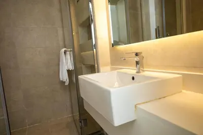 a bathroom with a white sink and a shower at Stunning Studio Apartment in Jvc in Dubai