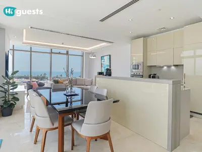 a kitchen and dining room with a table and chairs at HiGuests - Oceanfront Luxurious 3BR at Th8 Palm Dubai in Dubai