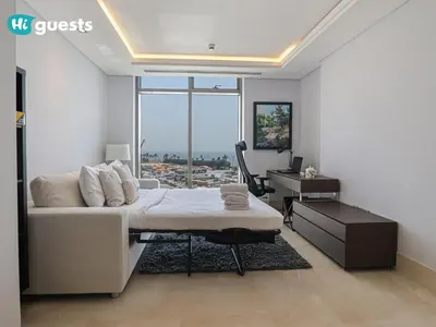 a bedroom with a bed and a desk in a room at HiGuests - Oceanfront Luxurious 3BR at Th8 Palm Dubai in Dubai