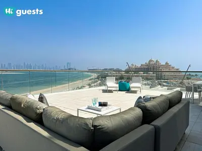 a couch sitting on top of a building next to the ocean at HiGuests - Oceanfront Luxurious 3BR at Th8 Palm Dubai in Dubai
