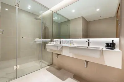 a bathroom with two sinks and a glass shower at Spacious 3BR Living, Walking Distance to Dubai Water Canal and Park, Near Safa Park Marine Transport Station, Canal Front 9B, Al Wasl by Deluxe Holiday Homes in Dubai