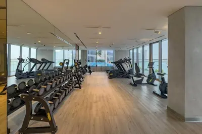 a gym with treadmills and elliptical machines at Spacious 3BR Living, Walking Distance to Dubai Water Canal and Park, Near Safa Park Marine Transport Station, Canal Front 9B, Al Wasl by Deluxe Holiday Homes in Dubai