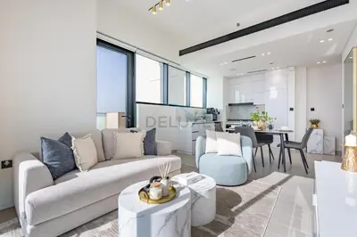 a living room with a couch and a table at Modern 2BR with Private Pool, Near Circle Mall And Quick Access from Al Khail Road, Binghatti Tulip, JVC by Deluxe Holiday Homes in Dubai