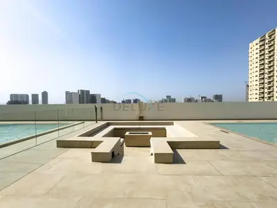 a pool with benches on top of a building at Modern 2BR with Private Pool, Near Circle Mall And Quick Access from Al Khail Road, Binghatti Tulip, JVC by Deluxe Holiday Homes in Dubai