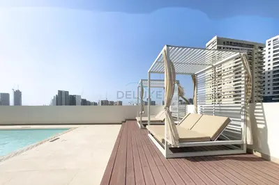 a lounge chair on the roof of a building at Modern 2BR with Private Pool, Near Circle Mall And Quick Access from Al Khail Road, Binghatti Tulip, JVC by Deluxe Holiday Homes in Dubai