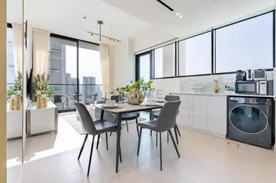 a kitchen and dining room with a table and chairs at Modern 2BR with Private Pool, Near Circle Mall And Quick Access from Al Khail Road, Binghatti Tulip, JVC by Deluxe Holiday Homes in Dubai