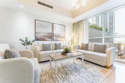 a living room with white furniture and large windows at Walking distance to Dubai Mall and Burj Khalifa, Easy access to Dubai Metro and Top attractions, Dunya Tower, Downtown Dubai by Deluxe Holiday Homes in Dubai