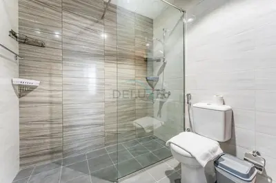 a bathroom with a toilet and a glass shower at Walking distance to Dubai Mall and Burj Khalifa, Easy access to Dubai Metro and Top attractions, Dunya Tower, Downtown Dubai by Deluxe Holiday Homes in Dubai