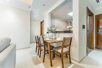 a dining room and kitchen with a wooden table and chairs at Walking distance to Dubai Mall and Burj Khalifa, Easy access to Dubai Metro and Top attractions, Dunya Tower, Downtown Dubai by Deluxe Holiday Homes in Dubai