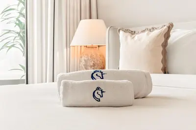 a pile of towels sitting on a bed at Beachfront Luxury 2BR with Breathtaking Views in Dubai