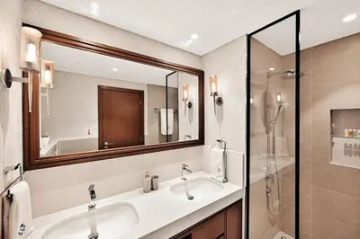 a bathroom with a sink and a shower and a mirror at Beachfront Luxury 2BR with Breathtaking Views in Dubai