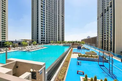 an image of a large swimming pool with tall buildings at 2BR Gem with Burj Khalifa View and Dubai Mall Access in Dubai