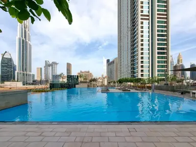 a large swimming pool in a city with tall buildings at 2BR Gem with Burj Khalifa View and Dubai Mall Access in Dubai