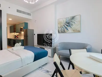 a bedroom with a bed and a table and a kitchen at Royalton - Private Pool Luxe Studio in Dubai in Dubai
