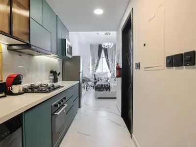 a kitchen with green cabinets and a stove top oven at Royalton - Private Pool Luxe Studio in Dubai in Dubai