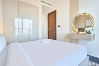 a bedroom with a white bed and a mirror at STAY BY LATINEM Luxury 1BR Holiday Home CB 1210 Near Burj Khalifa in Dubai