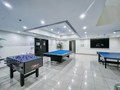 a large room with two pool tables and a tv at Stylish 1BR in Dubai Marina with Balcony, Pool & Walk to Beach in Dubai