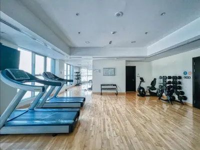 a gym with treadmills and exercise bikes in a room at Stylish 1BR in Dubai Marina with Balcony, Pool & Walk to Beach in Dubai