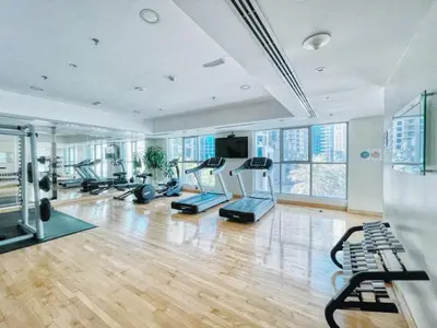 a gym with treadmills and exercise equipment in a building at Stylish 1BR in Dubai Marina with Balcony, Pool & Walk to Beach in Dubai