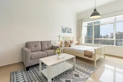 a living room with a bed and a couch at Chic Waterfront Location with Direct Metro Access and a Glimpse of Ain Dubai, Lake City Tower, Jumeirah Lake Towers by Deluxe Holiday Homes in Dubai