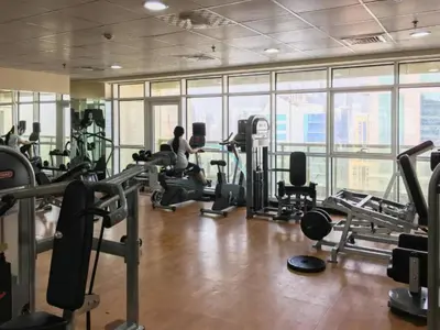 a gym with treadmills and machines in a building at Chic Waterfront Location with Direct Metro Access and a Glimpse of Ain Dubai, Lake City Tower, Jumeirah Lake Towers by Deluxe Holiday Homes in Dubai