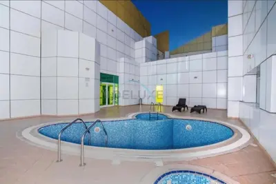 a large building with a hot tub in the middle at Chic Waterfront Location with Direct Metro Access and a Glimpse of Ain Dubai, Lake City Tower, Jumeirah Lake Towers by Deluxe Holiday Homes in Dubai