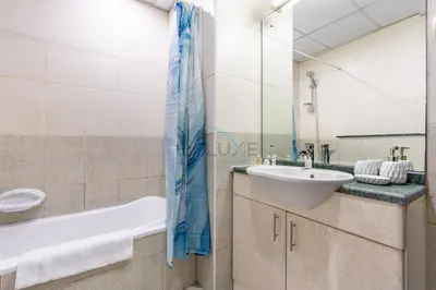 a bathroom with a sink and a mirror at Chic Waterfront Location with Direct Metro Access and a Glimpse of Ain Dubai, Lake City Tower, Jumeirah Lake Towers by Deluxe Holiday Homes in Dubai