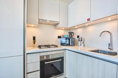 a kitchen with white cabinets and a stove top oven at STAY BY LATINEM Luxury 1BR Holiday Home CB 1807 Near Downtown in Dubai