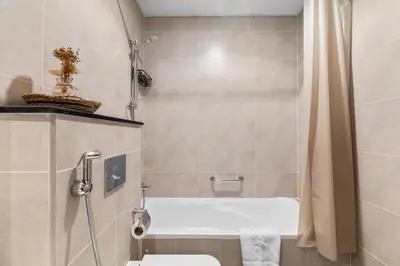 a bathroom with a tub and a toilet and a shower at BirdsEye Cozy Studio Mesmerizing Golf Views in Dubai
