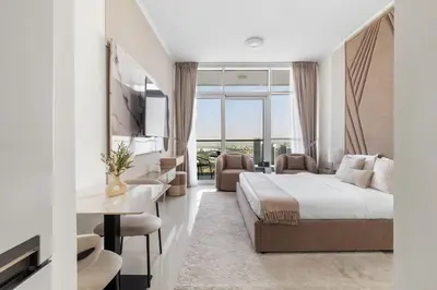 a hotel room with a king sized bed and a desk at BirdsEye Cozy Studio Mesmerizing Golf Views in Dubai