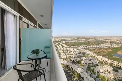 a balcony with a table and chairs and a view at BirdsEye Cozy Studio Mesmerizing Golf Views in Dubai