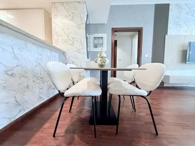 a dining room with a table and white chairs at Charming 1 BR with Balcony Retreat in Dubai