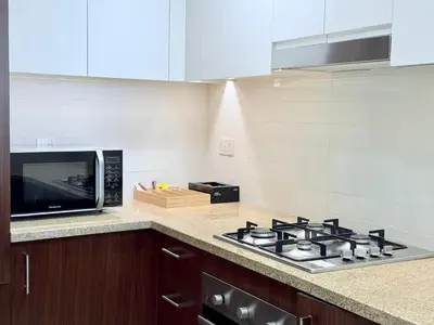 a kitchen with a stove and a microwave at Charming 1 BR with Balcony Retreat in Dubai