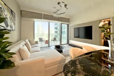 a living room with a white couch and a tv at Luxury 1-Bedroom Apartment with Full Marina View in Dubai