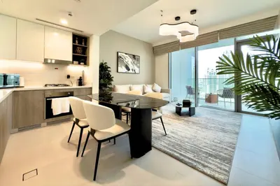 a kitchen and living room with a table and chairs at Luxury 1-Bedroom Apartment with Full Marina View in Dubai