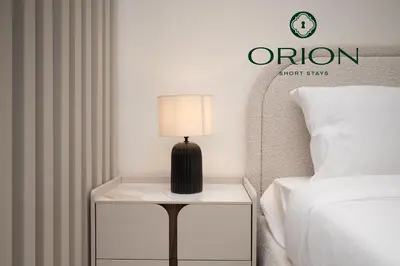 a lamp on a night stand next to a bed at Stunning Luxury Studio with Jacuzzi and Canal View on High Floor, Close to Dubai Mall, Swimming Pool, Advanced Gym with PT, Sauna, Steam Room, Ice Bath, Swimming Pool, Best Building in Area in Dubai
