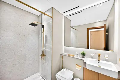 a bathroom with a shower and a toilet and a sink at Golden Stays - Private Pool in Binghatti Gardenia I Coastal Charm I Luxe 2BR Escape in Dubai