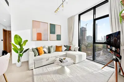 a living room with a white couch and a large window at Golden Stays - Private Pool in Binghatti Gardenia I Coastal Charm I Luxe 2BR Escape in Dubai