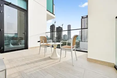 a balcony with a table and chairs on a building at Golden Stays - Private Pool in Binghatti Gardenia I Coastal Charm I Luxe 2BR Escape in Dubai