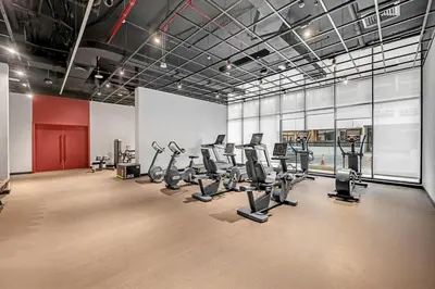 a gym with treadmills and ellipticals in a room at Waves - Cozy & Modern JVC Escape With Pool & Gym Access in Dubai