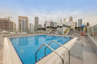 a large swimming pool on top of a building at Waves - Cozy & Modern JVC Escape With Pool & Gym Access in Dubai