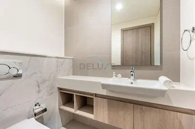 a white bathroom with a sink and a mirror at Panoramic High-Floor 1BR Overlooking Yachts and Dubai Water Canal, Moments from JBR Beach, LIV MarinaMarine Transport, and Skydive Dubai, LIV Marina, Dubai Marina by Deluxe Holiday Homes in Dubai