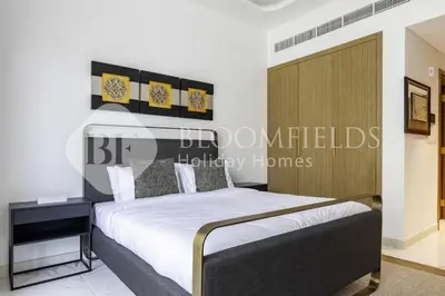 a bedroom with a bed with a wooden headboard at Bloomfeilds Comfortable STU Azizi Rivera in Dubai