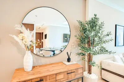 a living room with a mirror and a couch at Luxury 2BR Retreat Gorgeous Beach & Skyline Views in Dubai