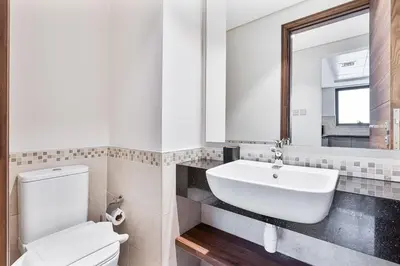 a bathroom with a sink and a toilet and a mirror at Radiant - 3BR - JVC - near Sports City & Autodrome in Dubai