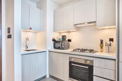 a kitchen with white cabinets and a stove top oven at STAY BY LATINEM Luxury 1BR Holiday Home CB 0919 Near Burj Khalifa in Dubai