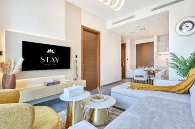 a living room with a tv on a wall at STAY BY LATINEM Luxury 1BR Holiday Home CB 0919 Near Burj Khalifa in Dubai