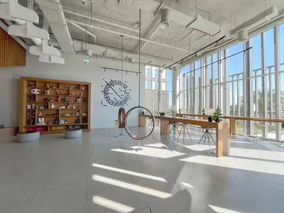 a large room with a table and a clock on the wall at 1BR in Collective With Pool, Gym and CoWorking Space in Dubai