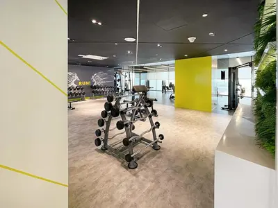 an office with a gym with a chair and weights at Chic Studio in Dubai with Pool View Retreat Near Business Bay & Jumeirah Beach in Dubai