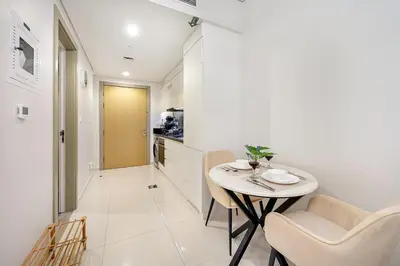 a dining room with a table and chairs and a hallway at Chic Studio in Dubai with Pool View Retreat Near Business Bay & Jumeirah Beach in Dubai